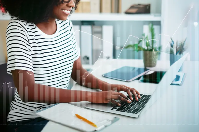 Mulher empreendedora sorrindo em frente ao notebook Mulher empreendedora sorrindo usando notebook com ferramentas de negócio gratuitas